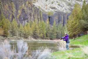 Woman Fly Fishing from banks of Wild River in central Oregon