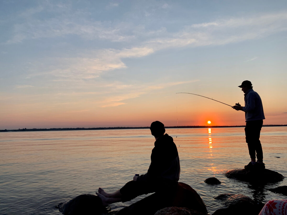 Fishing from the lake shore at sunset in Manitoba